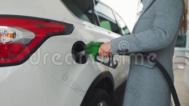 女人在加油站给她的车加满汽油。 慢动作